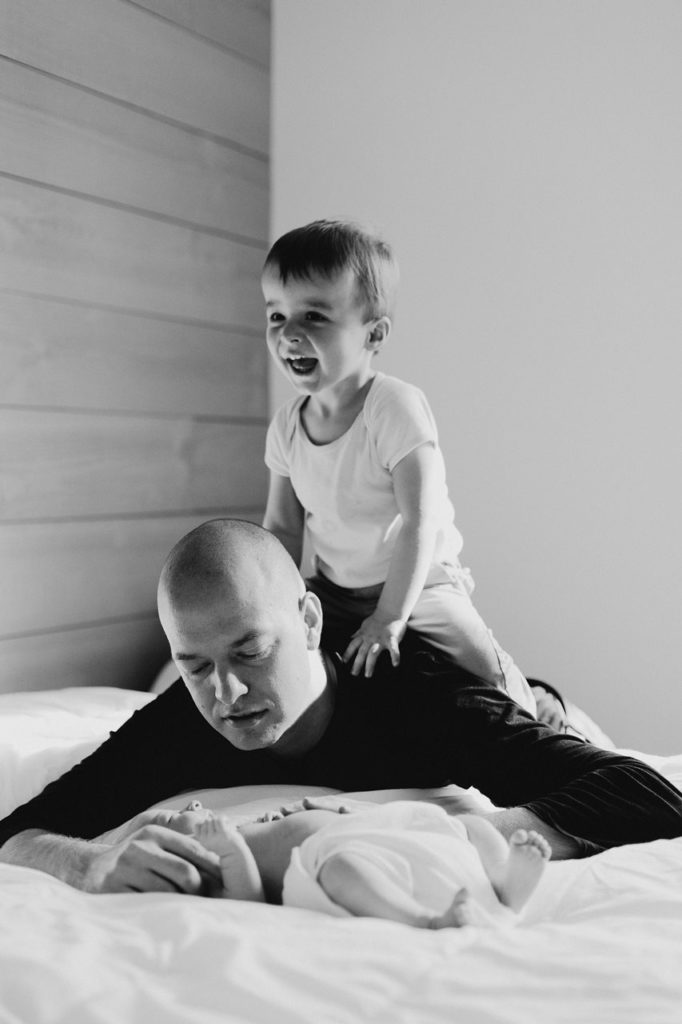 séance nouveau-né lifestyle instants jeux et calîn papa enfants noir et blanc