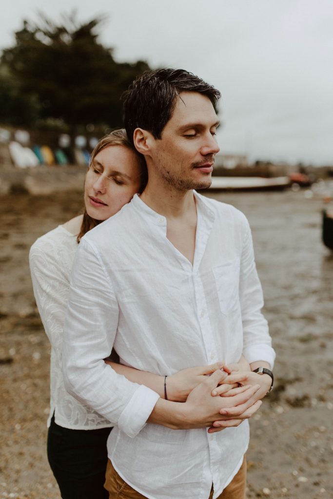 portrait couple câlin plage yeaux fermés ciel gris